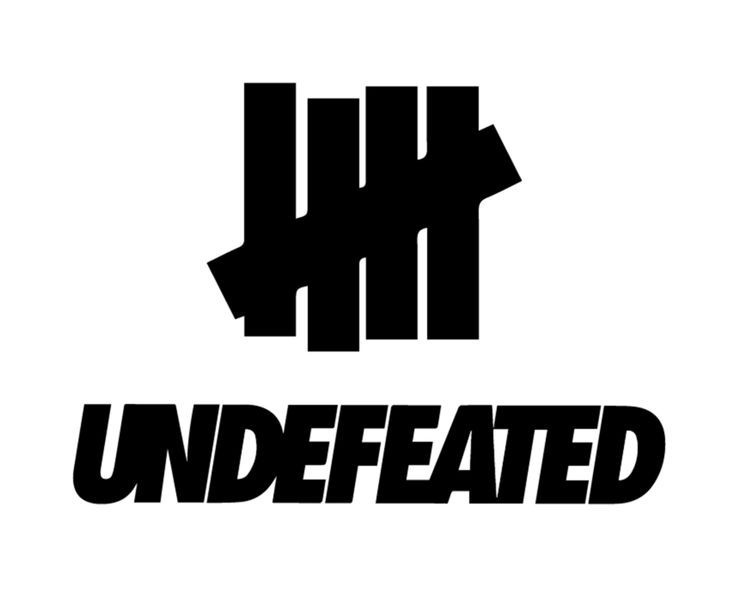 Black unbeaten logo with bold stylized lettering and geometric emblem above brand name in undefeated collection