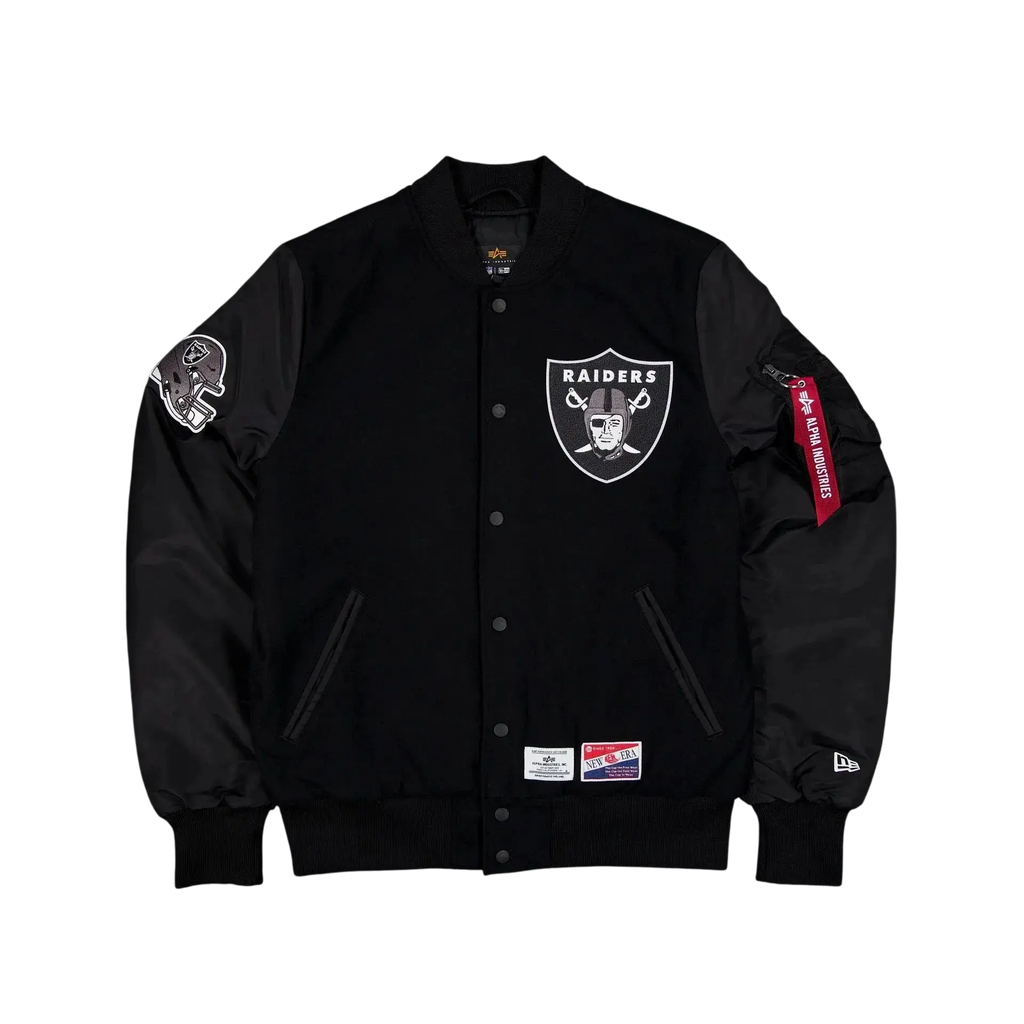 Black bomber jacket by Alpha Industries x New Era featuring white Raiders logo chest, shoulder patches, and branded tag