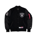 Black bomber jacket by Alpha Industries x New Era featuring white Raiders logo chest, shoulder patches, and branded tag