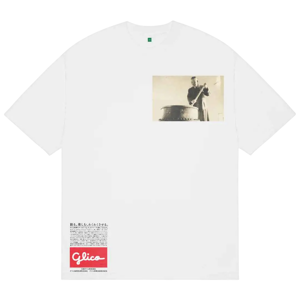 White cotton b.Eautiful Guriko T-shirt featuring a vintage black and white photo of a man playing drum with Glico logo