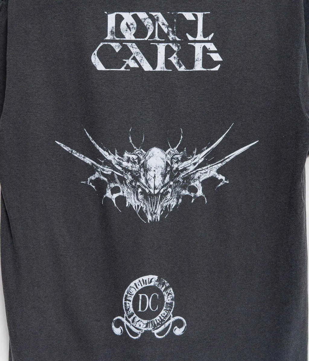 Black sleeveless t-shirt featuring a white distressed dont care graphic with an intricate winged skull and circular dc emblem