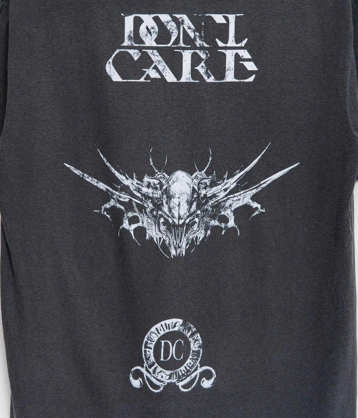 Black sleeveless t-shirt featuring a white distressed dont care graphic with an intricate winged skull and circular dc emblem