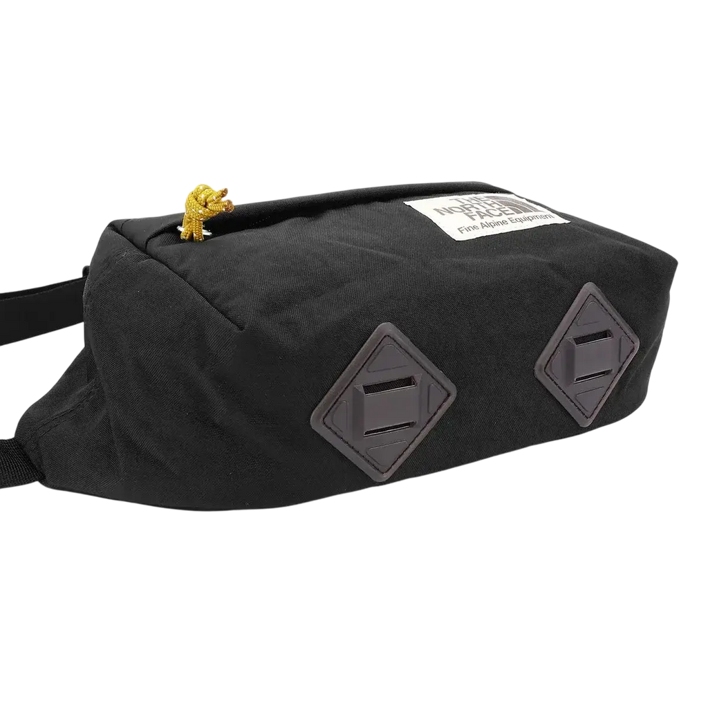 North face berkley lumbar bag in black and mineral gold with diamond gray patches and gold lion charm on top