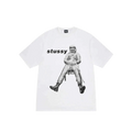 White Stussy astronaut tee featuring a black and white graphic of an astronaut seated on a chair on the front