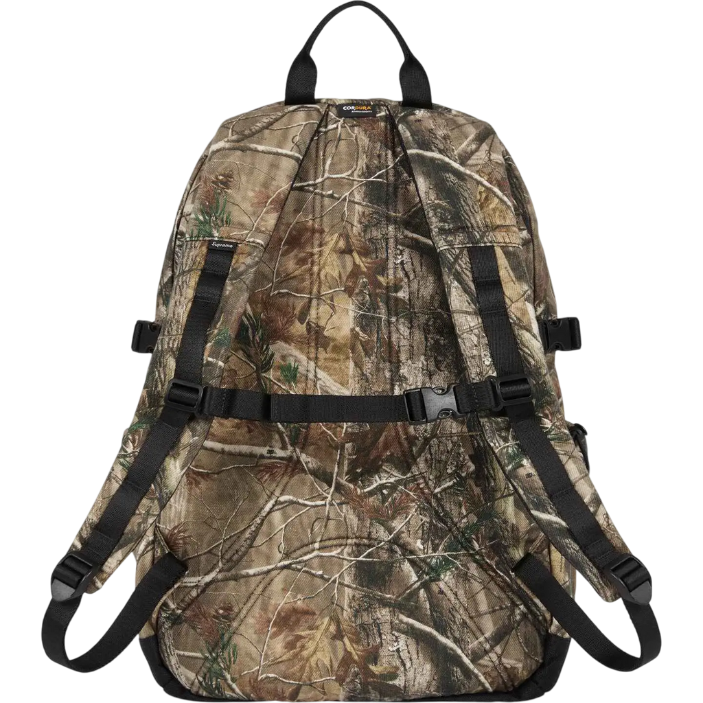 Supreme denim backpack camo fw25 with camouflage pattern black straps top handle and subtle brand tags