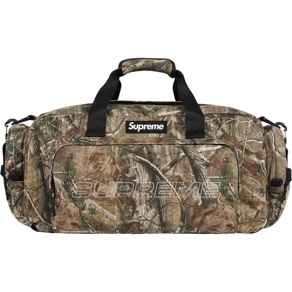 Supreme denim duffle camo fw25 bag with camouflage pattern black handles and prominent white logo patch