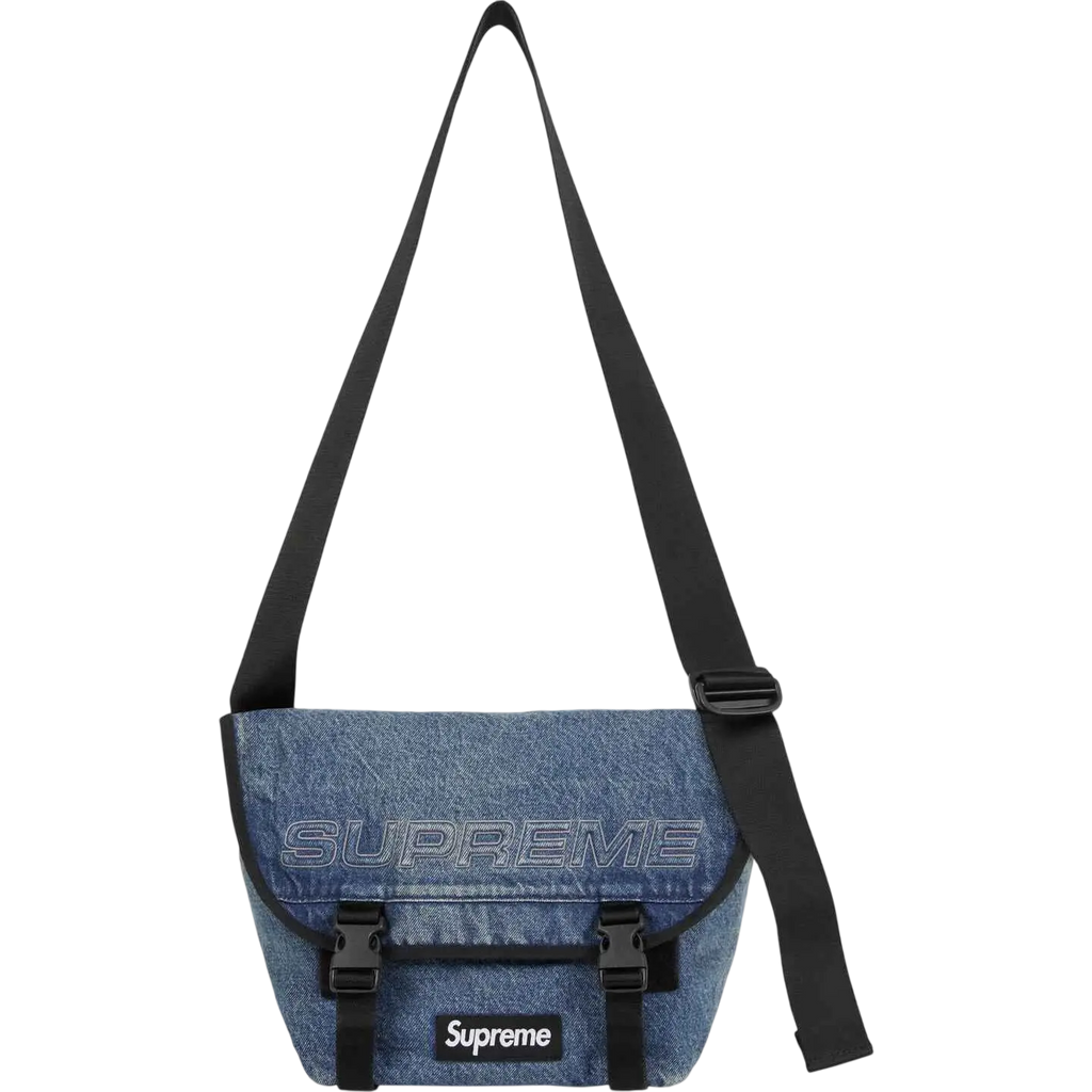 Blue denim supreme messenger bag with black strap and logo patches in washed indigo for fw25 collection
