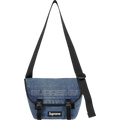 Blue denim supreme messenger bag with black strap and logo patches in washed indigo for fw25 collection