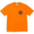Bright orange supreme devotion t-shirt with short sleeves and a black circular graphic on the left chest