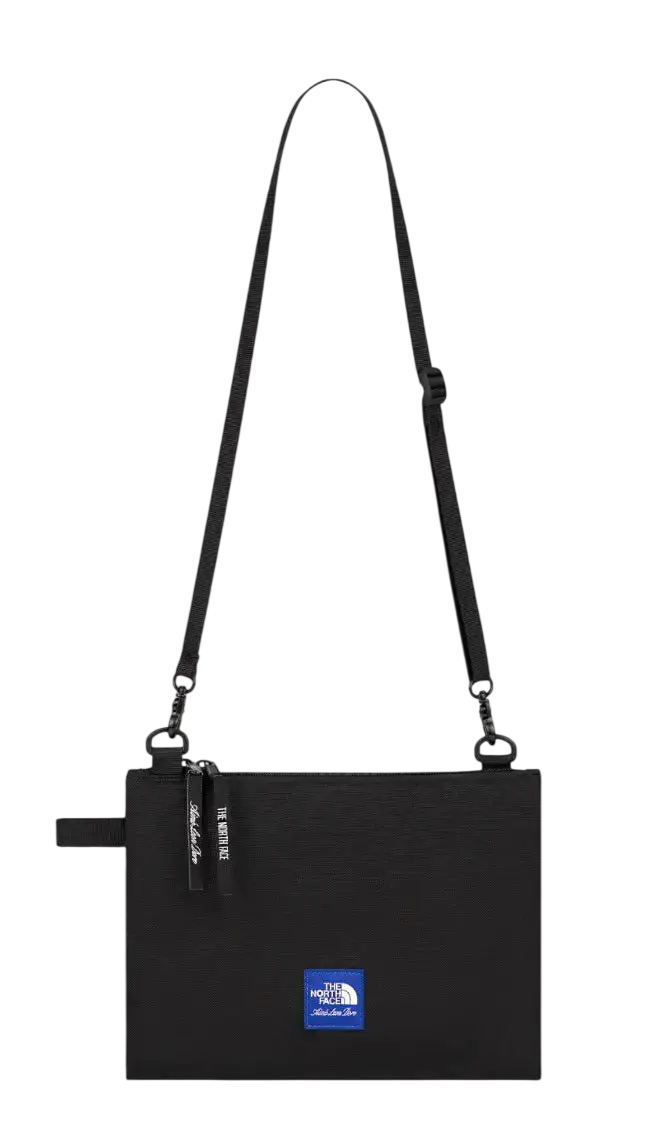 Black the north face shoulder bag with a blue logo patch and adjustable strap.