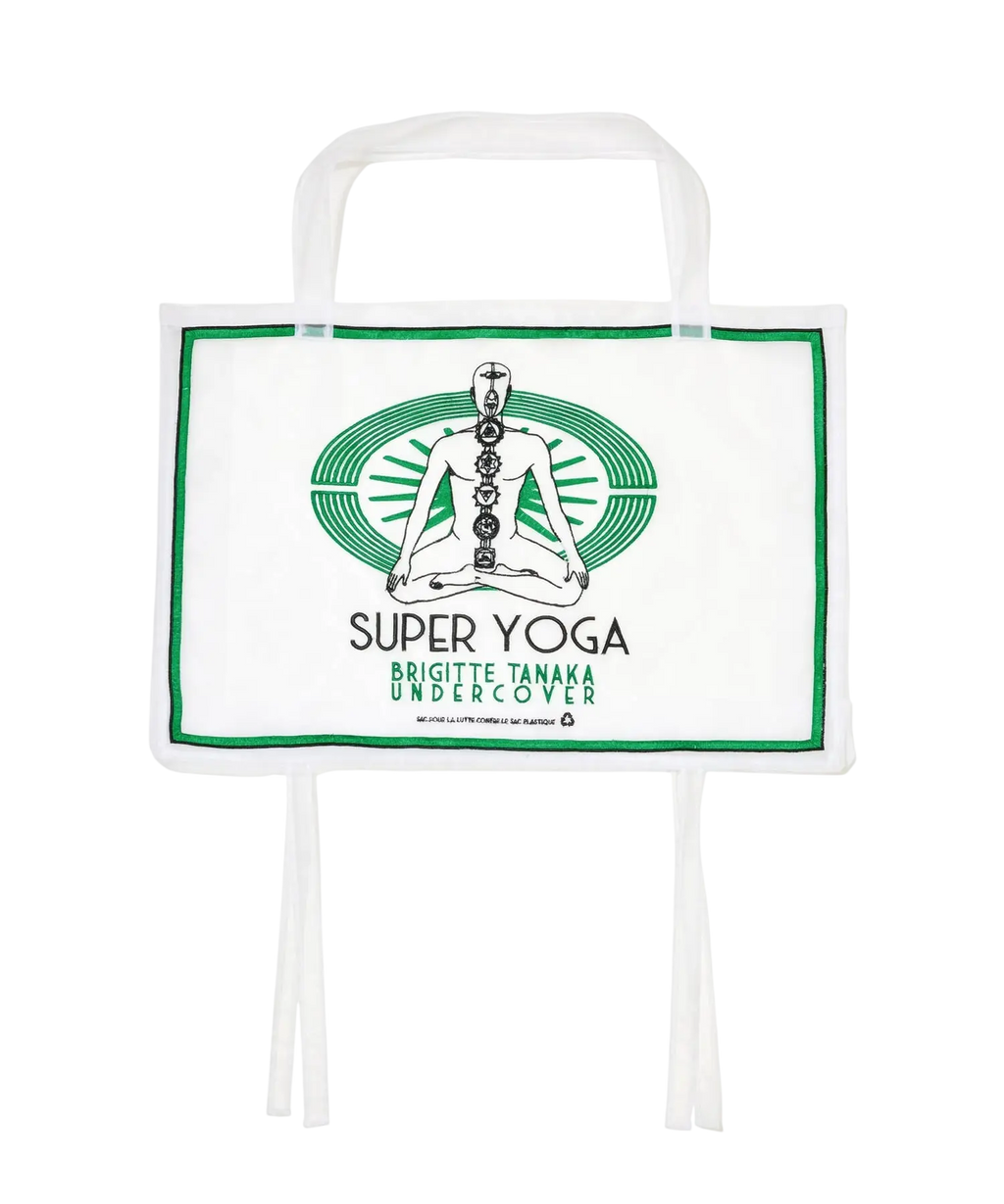 Undercover women’s white tote bag with green border and meditating figure graphic for yoga use