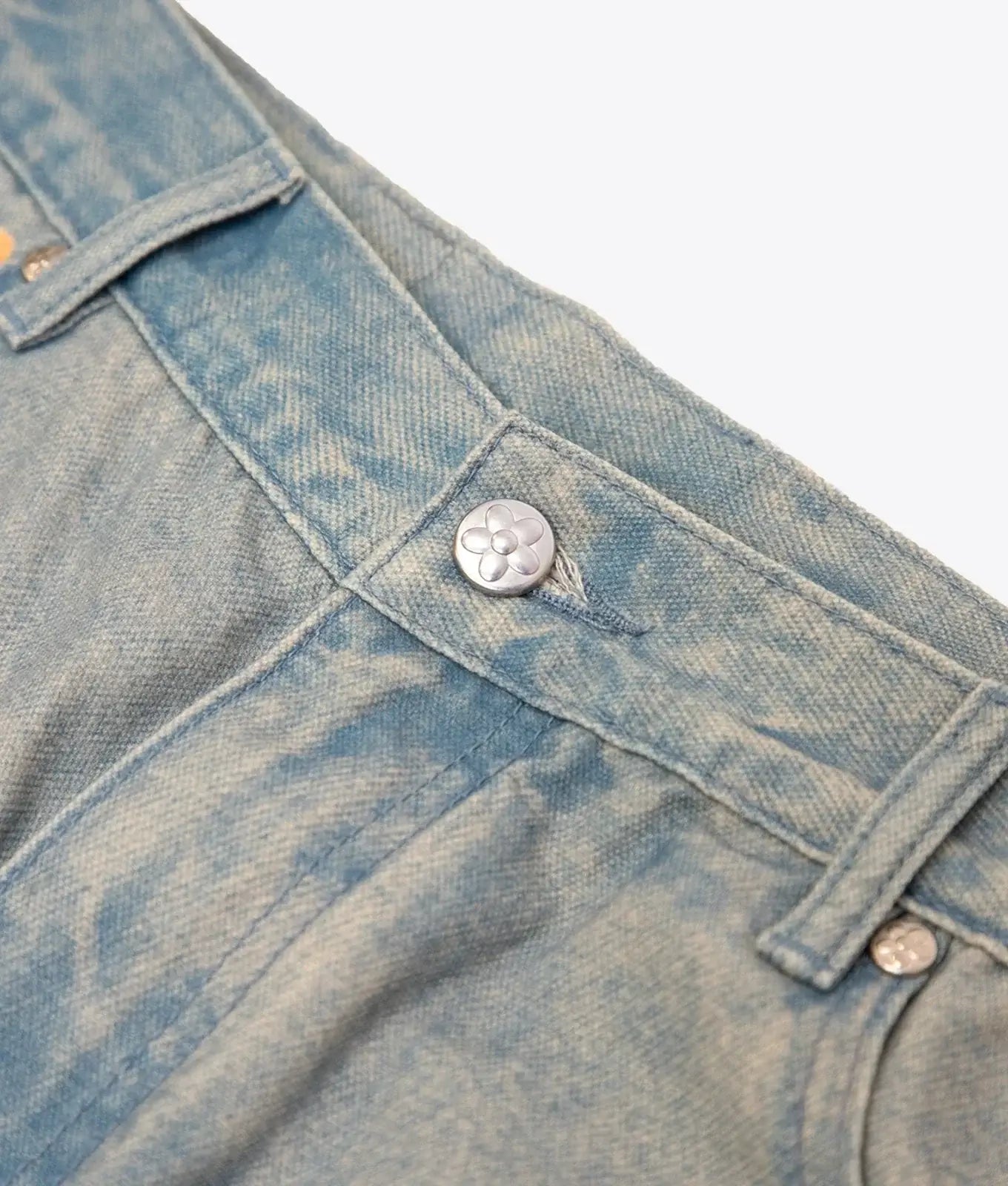 Silver floral button detail on light-wash denim jeans from vandy the pink fries trompe loeil denim