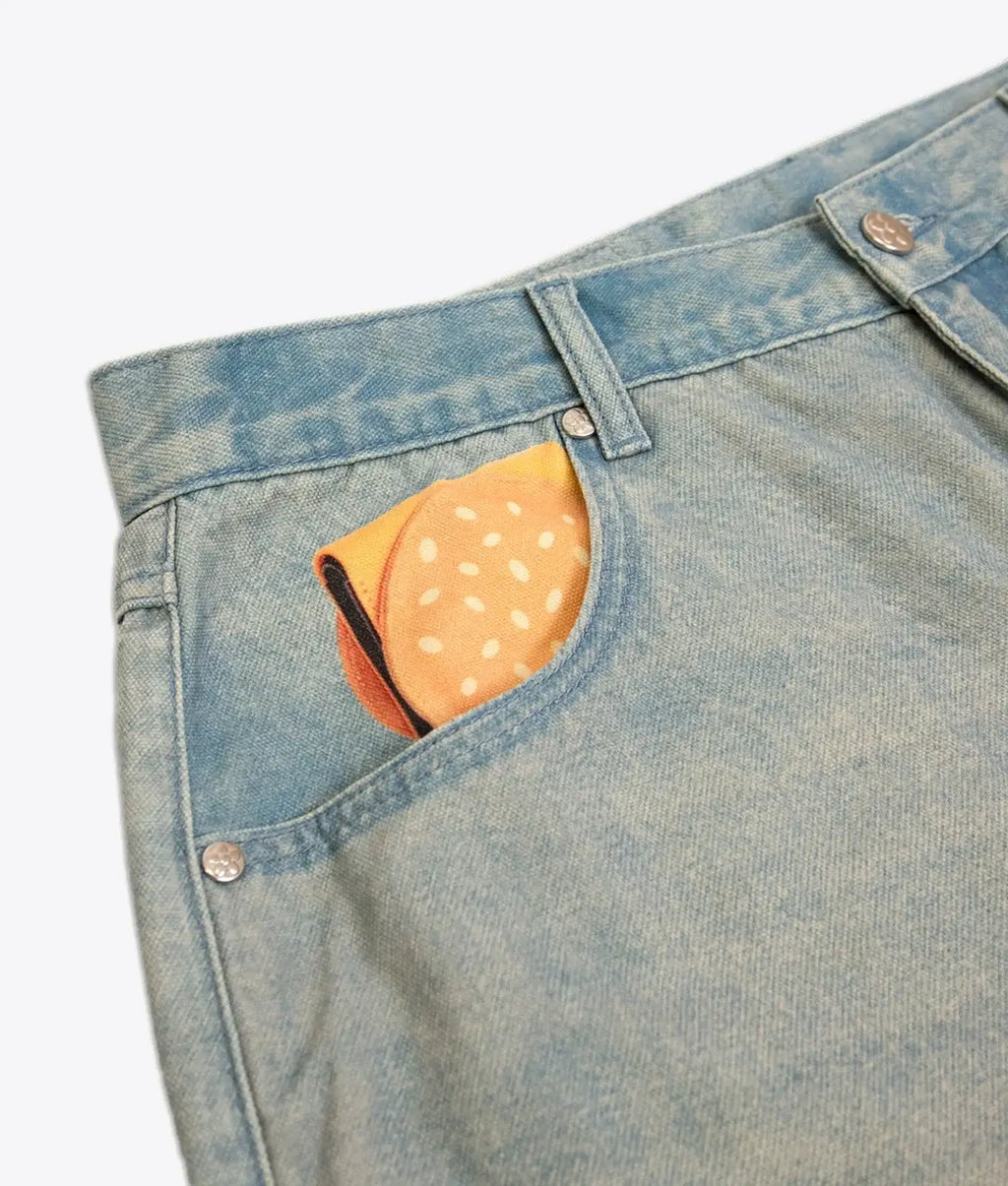 A vibrant orange polka dot pocket square tucked into the front pocket of vandy the pink fries trompe loeil denim jeans