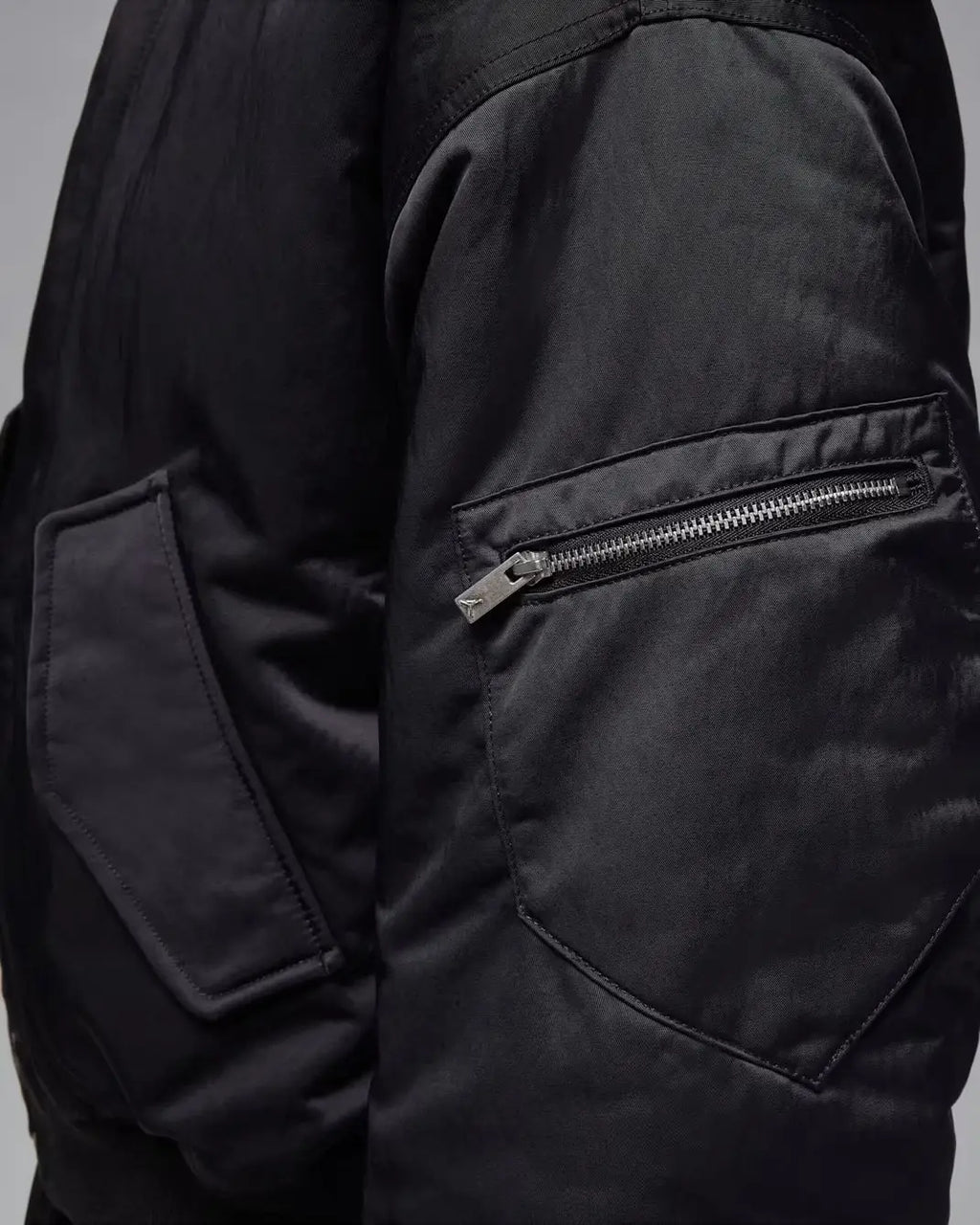 Women’s Jordan Flight Renegade bomber jacket in black nylon with a silver zipper on the sleeve pocket