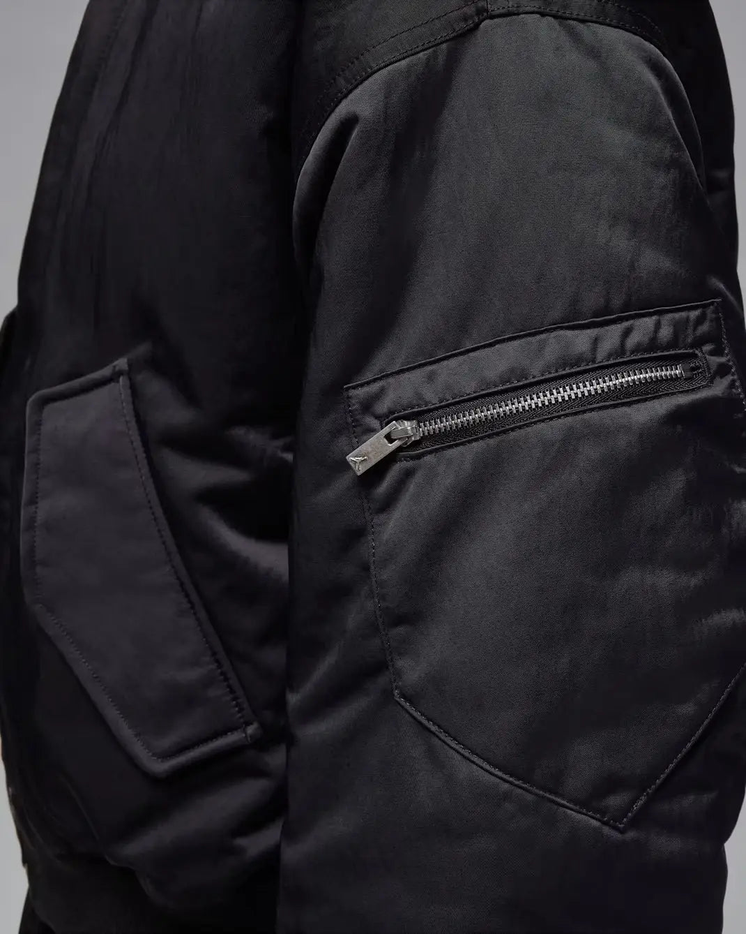 Women’s Jordan Flight Renegade bomber jacket in black nylon with a silver zipper on the sleeve pocket