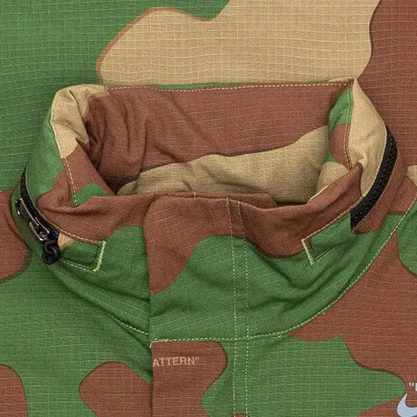 Close up of interior lining and zipper of women’s Nike x Off White NRG jacket in green brown beige camo pattern